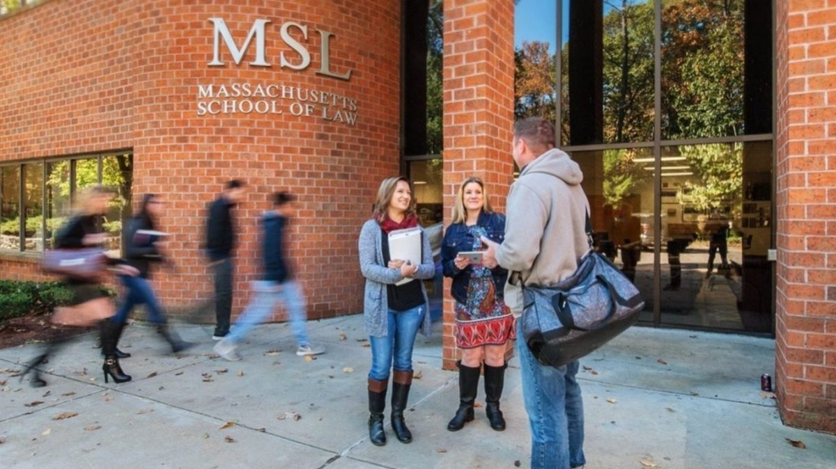 Massachusetts School of Law in Final Week for Fall Admissions 5 Three students conversing outside the Massachusetts School of Law brick building entrance with MSL signage, fall foliage v...